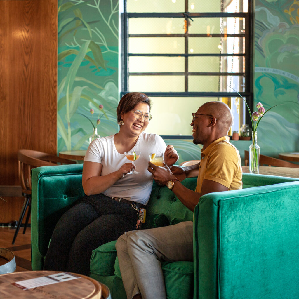 two people on a couch with cocktails