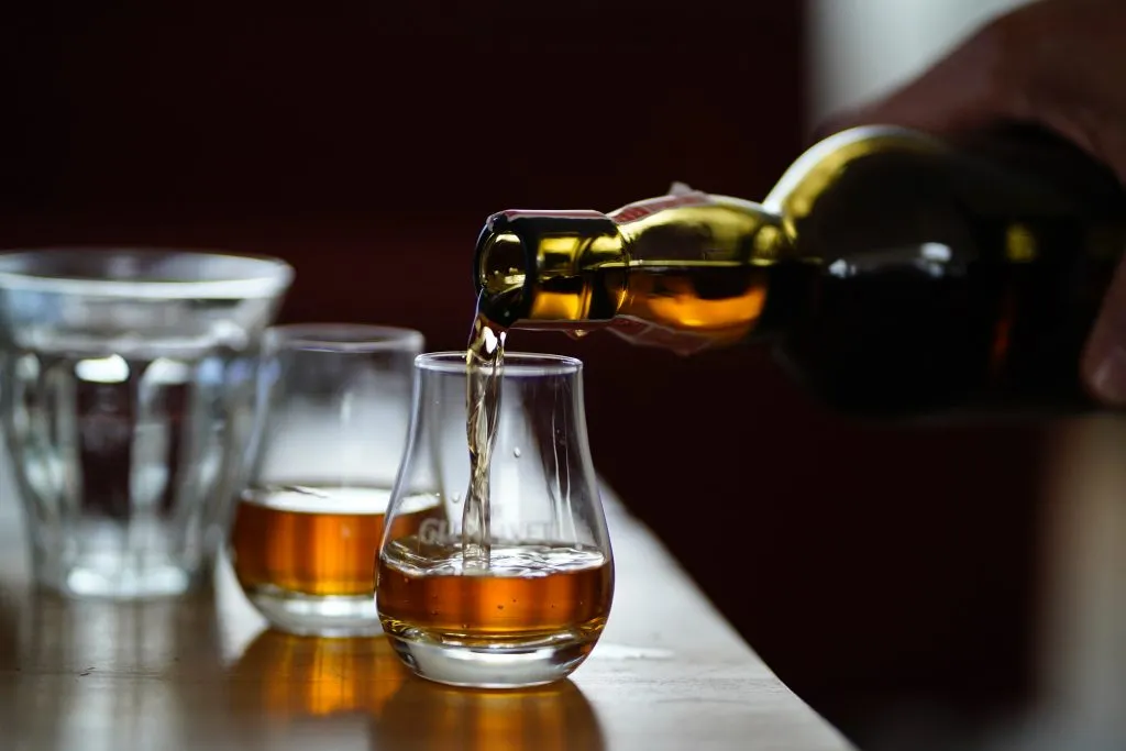 spirit being poured into short glass